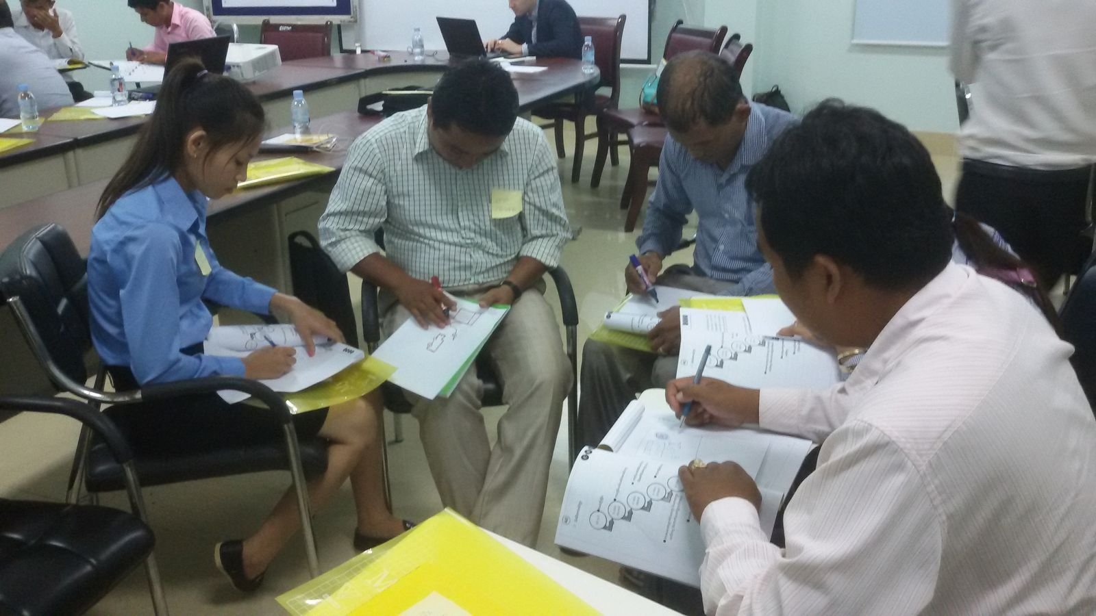 A group gathered around a table sketching out ideas on a large sheet of paper